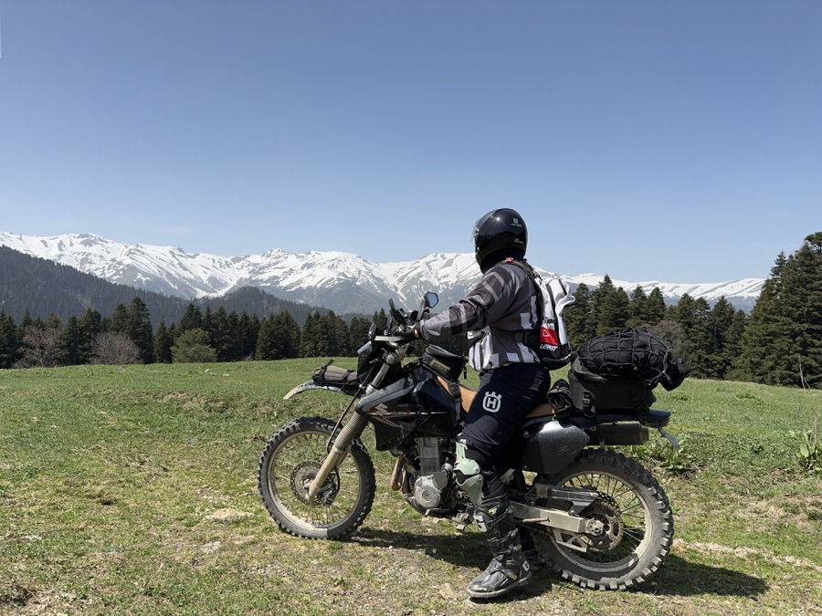 Suzuki DR-Z400S with rider overlooking snowy mountains