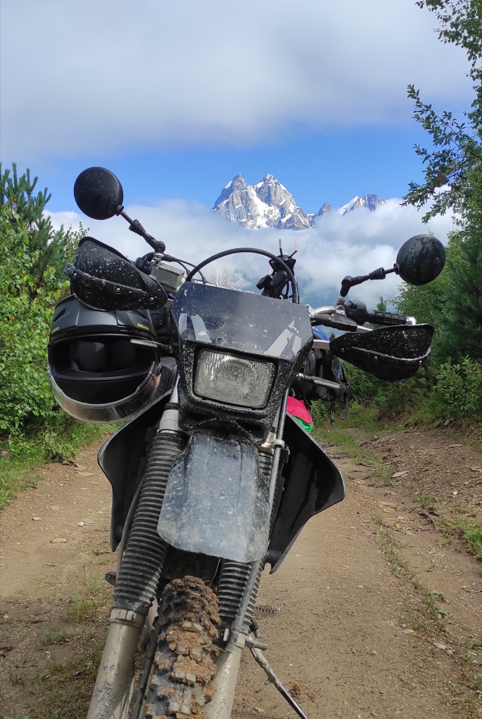 2014 Suzuki DR-Z400S on a mountain trail with snowy peaks behind it